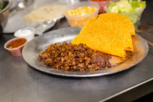 A plate of meat and three taco shells